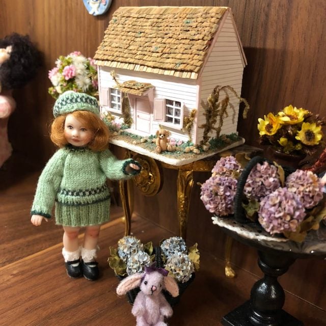 Miniature girl and dollhouse